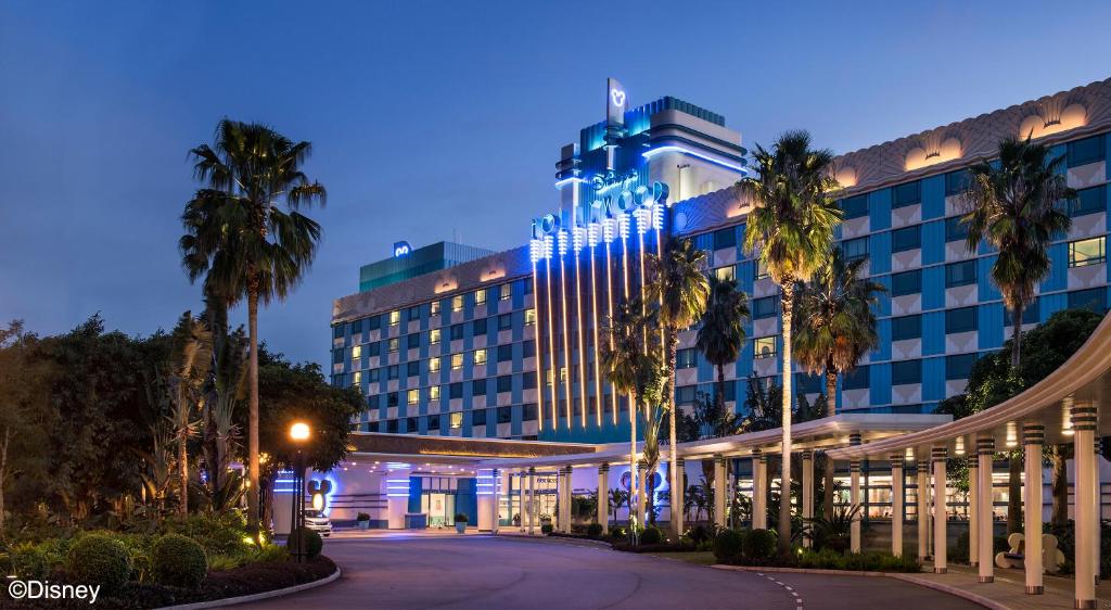 un grande edificio con palme di fronte di Disney's Hollywood Hotel a Hong Kong