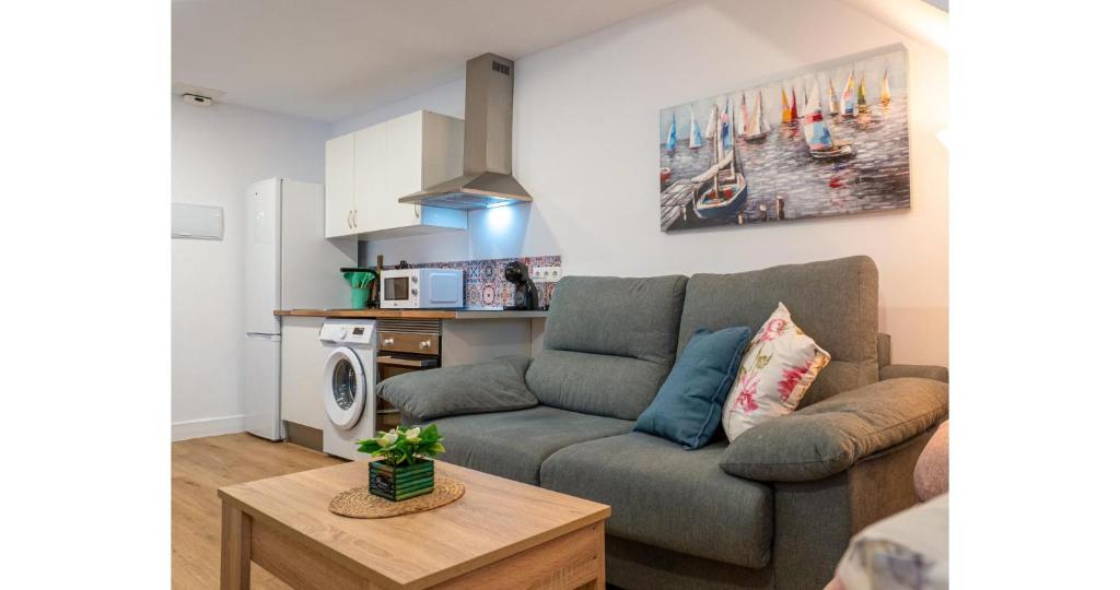 a living room with a couch and a kitchen at YourHouse Apartamentos Andasol 1 I in Chipiona