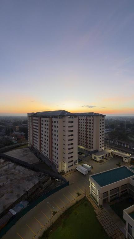 an aerial view of a building with a sunset in the background at Modern 2-Bedroom Apartment Near Kisumu CBD, Free WiFi, Parking & Security in Kisumu