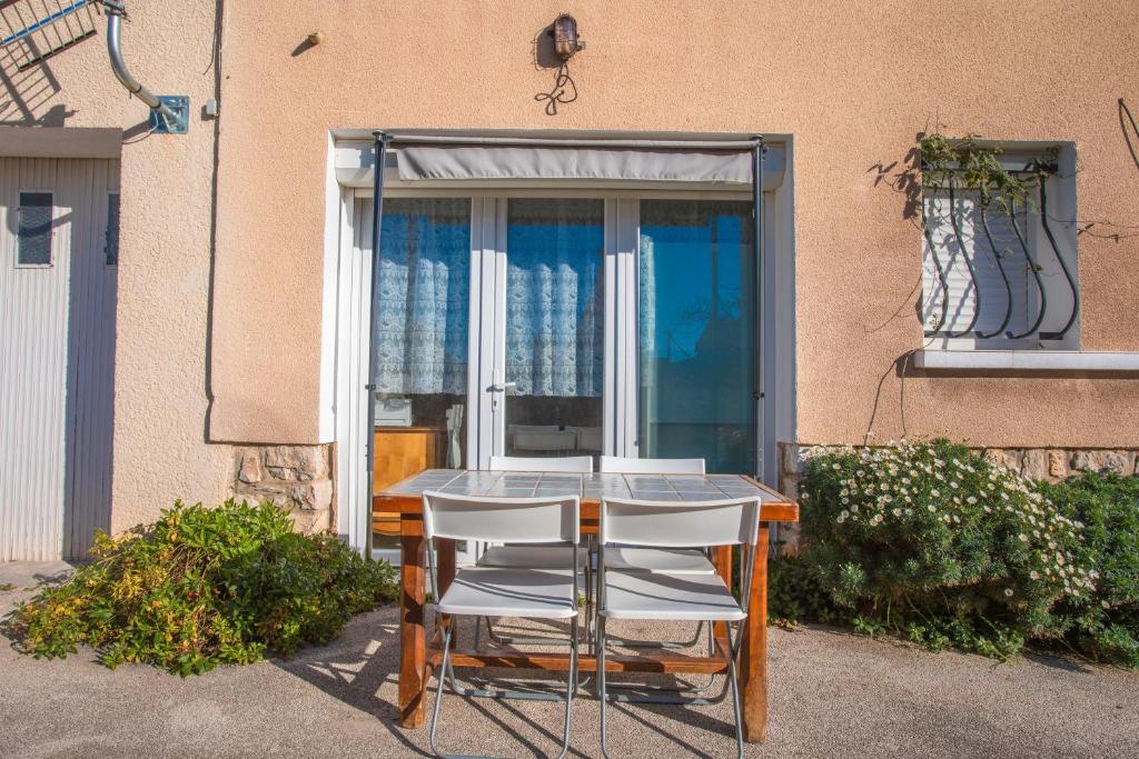 een tafel en stoelen voor een raam bij Studio proche plage clim et parking in Carqueiranne