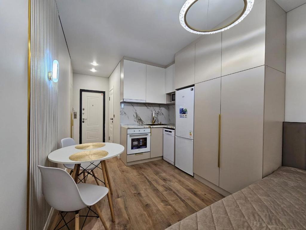 a kitchen with a table and chairs in a room at Rams city квартира in Zhezdi