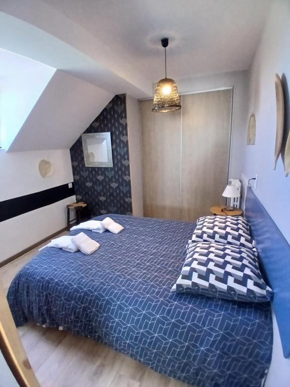 een slaapkamer met een blauw bed en een blauw dekbed bij La Tour Des Quatre Chemins in Gramat
