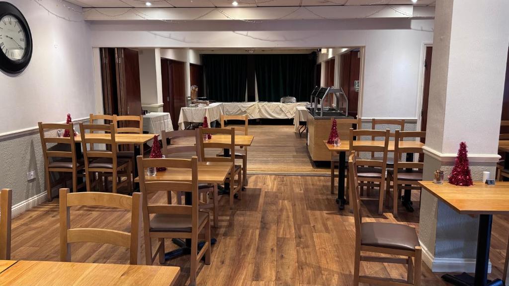 een restaurant met houten tafels en stoelen en een klok bij The March Hotel in March