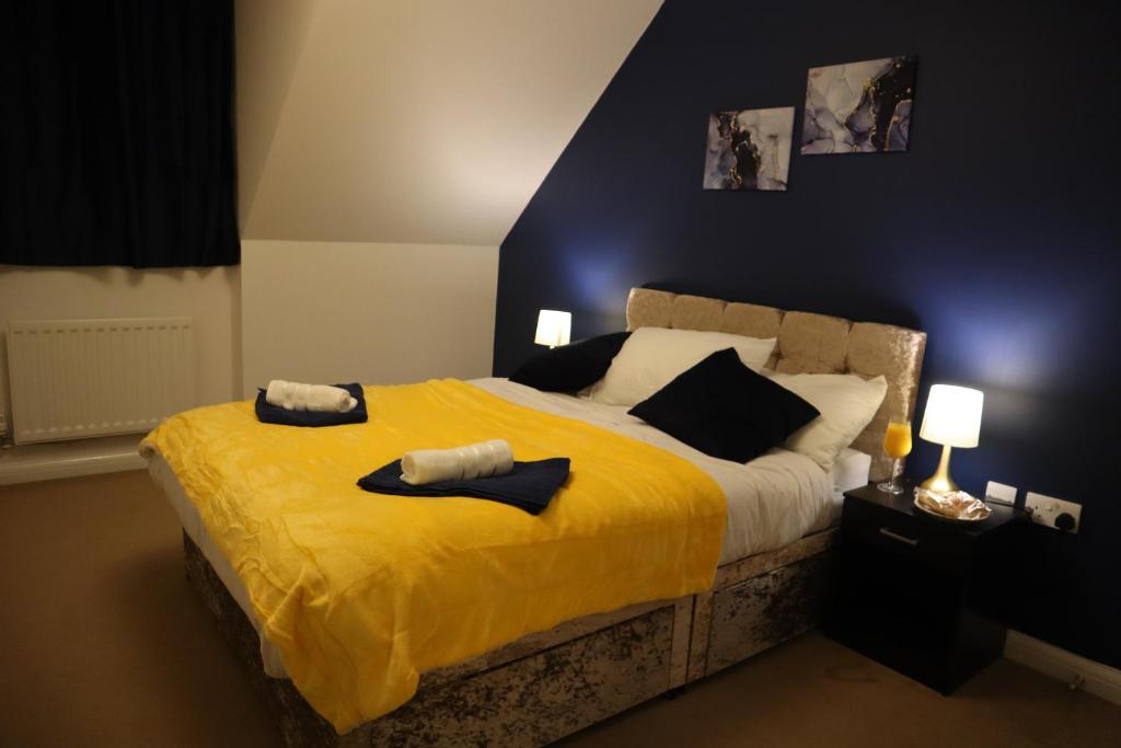 une chambre avec un lit jaune avec deux serviettes dessus dans l'établissement Duxford Haven, à Duxford