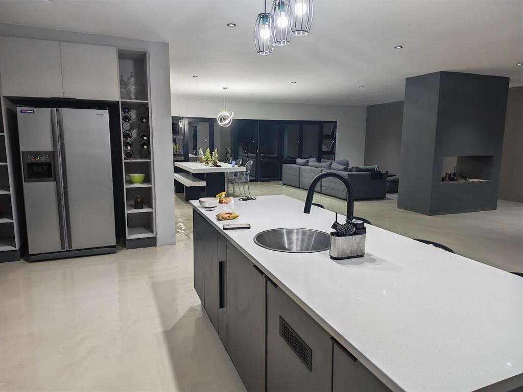 een keuken met een spoelbak en een woonkamer bij Tee Off House in Parys