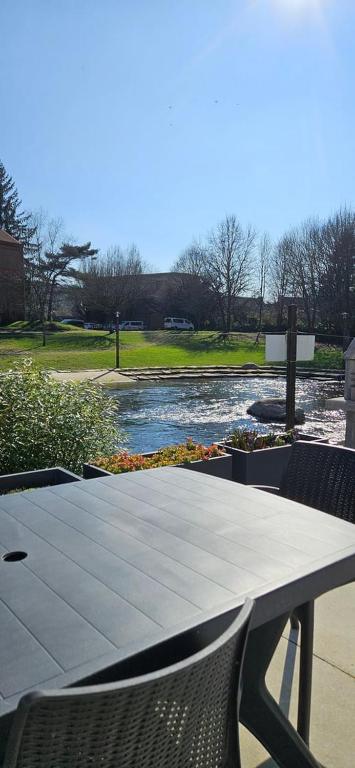 een tafel met twee stoelen naast een rivier bij Maison au bord du Blavet in Le Pener