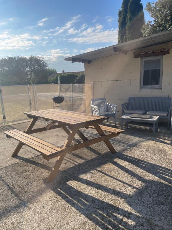 einem Picknicktisch aus Holz vor einem Gebäude in der Unterkunft SERENITY Gite indépendant dans propriété avec piscine in Servian