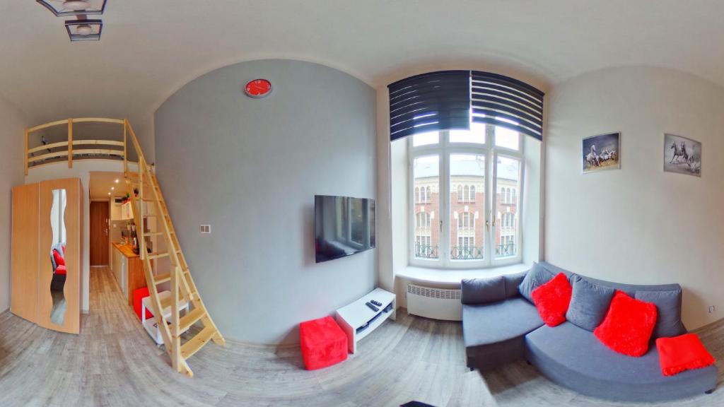 - un salon avec un canapé bleu et une échelle dans l'établissement Apartamenty Marco - Stare Miasto - Super Wi Fi, à Cracovie