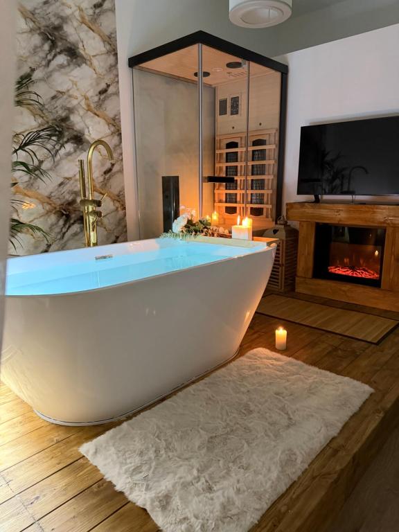 une baignoire blanche dans une salle de bain avec cheminée dans l'établissement Ama Esclusive Spa Florence, à Florence