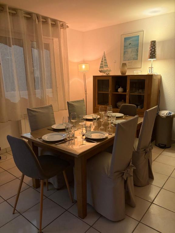 a dining room table and chairs with wine glasses on it at Le nid du bouloir in Lisieux