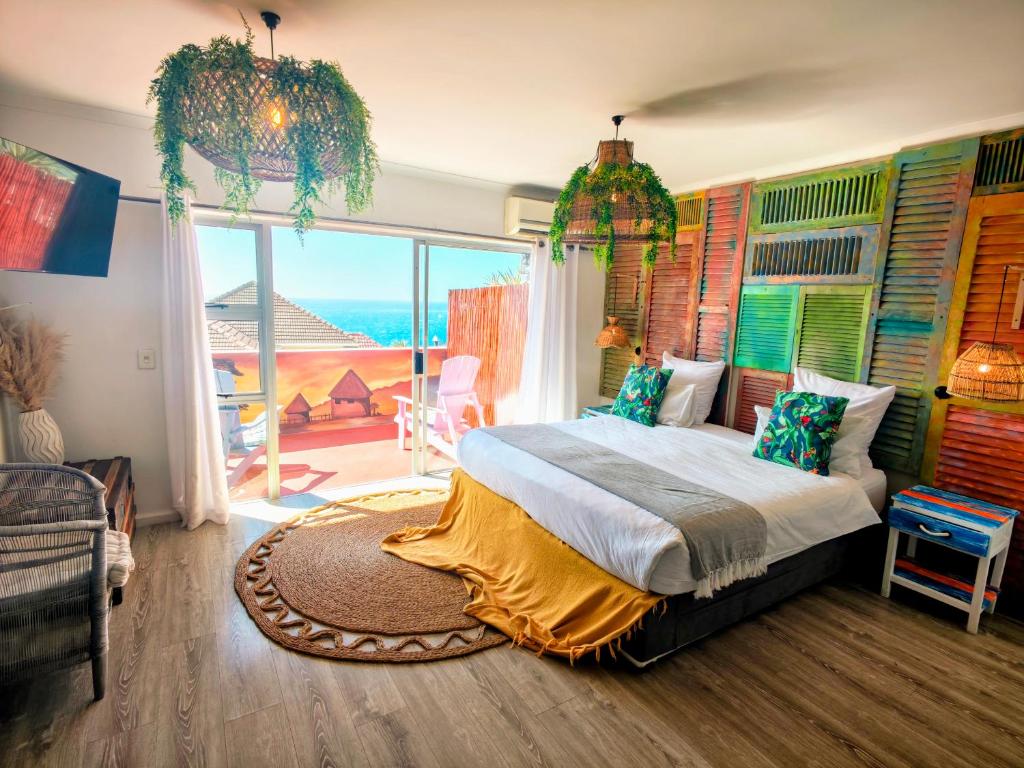 een slaapkamer met een bed met uitzicht op de oceaan bij African Groove Camps Bay in Kaapstad