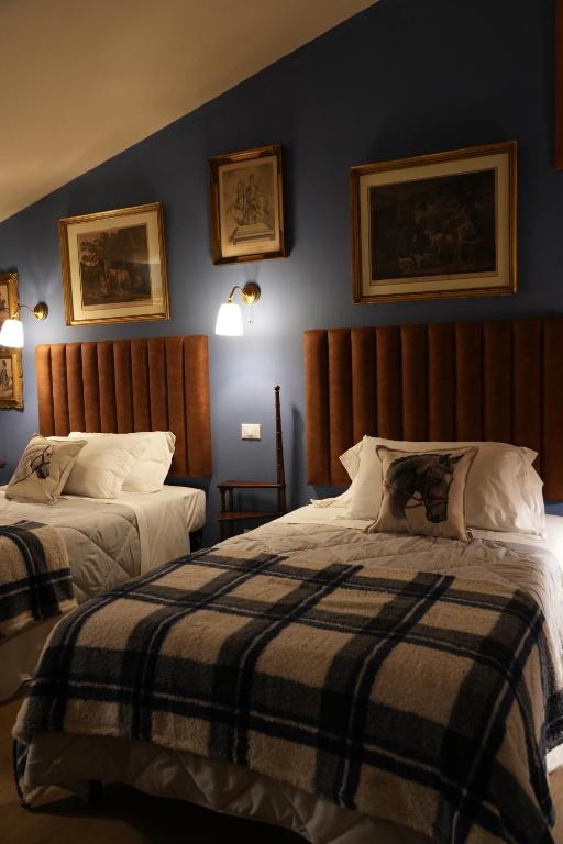 a bedroom with two beds and two pictures on the wall at La Dimora di Luca in Bientina