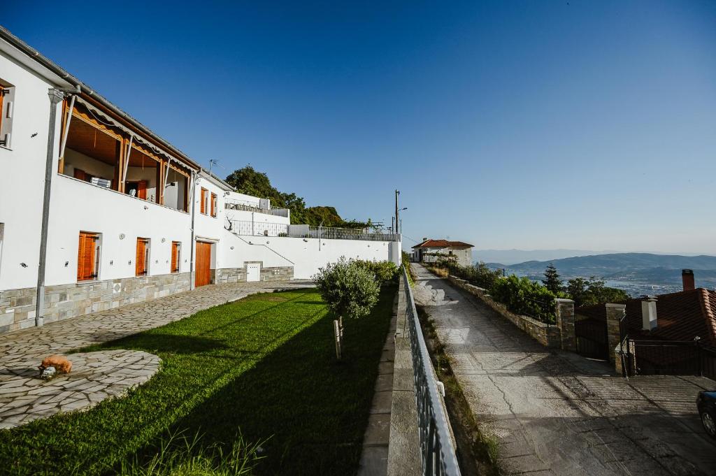un cane steso sull'erba accanto a un edificio di Panoramic View Villa a Stagiates