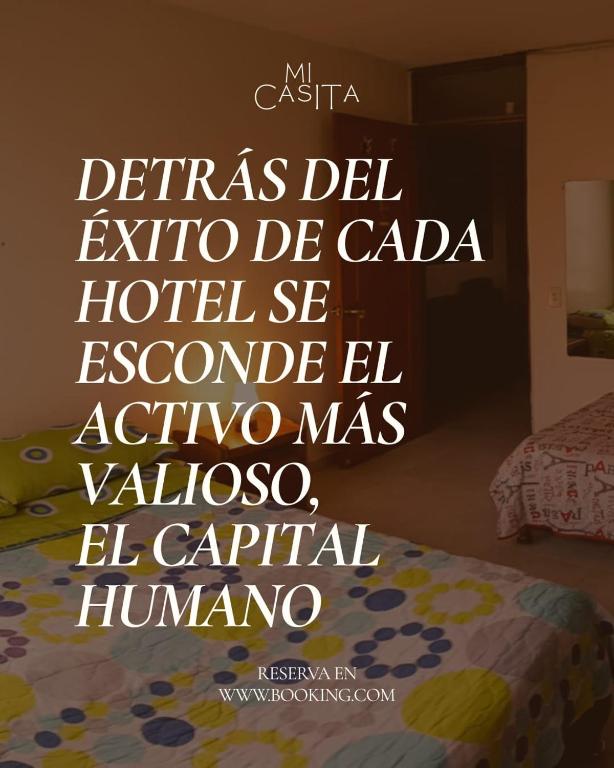 a sign on a wall above a bed in a room at Hotel mi casita in Bogotá