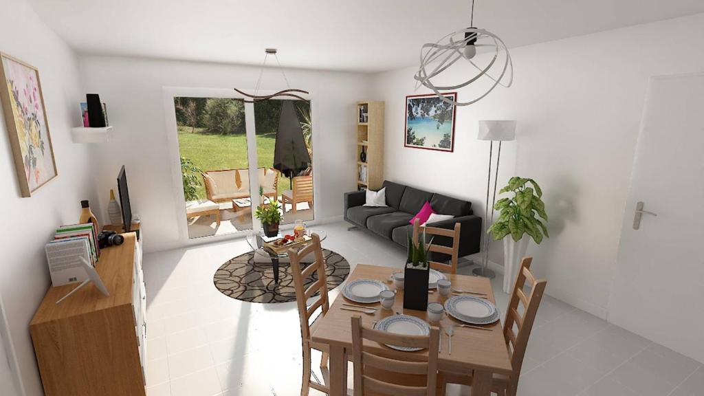 a living room with a table and a couch at Les Bastides in Mimizan