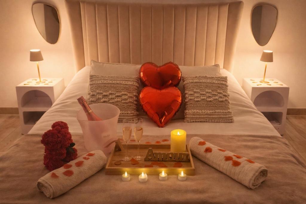 ein Bett mit einem herzförmigen Kissen und einer Kerze darauf in der Unterkunft Love Room - Cocon Room - Toulon - Ollioules in Ollioules