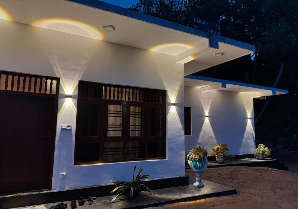 a white house with lights on the side of it at Midigama Lucky Villa in Midigama East