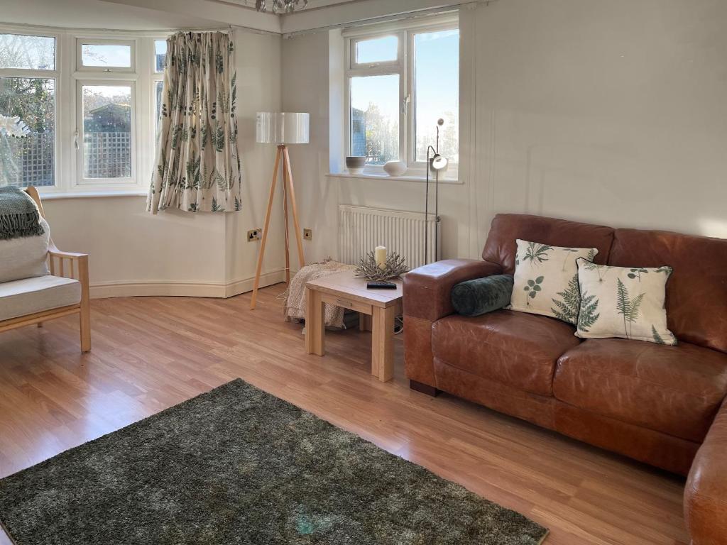 een woonkamer met een bruine leren bank en een tafel bij Island House - Uk51001 in Little Baddow