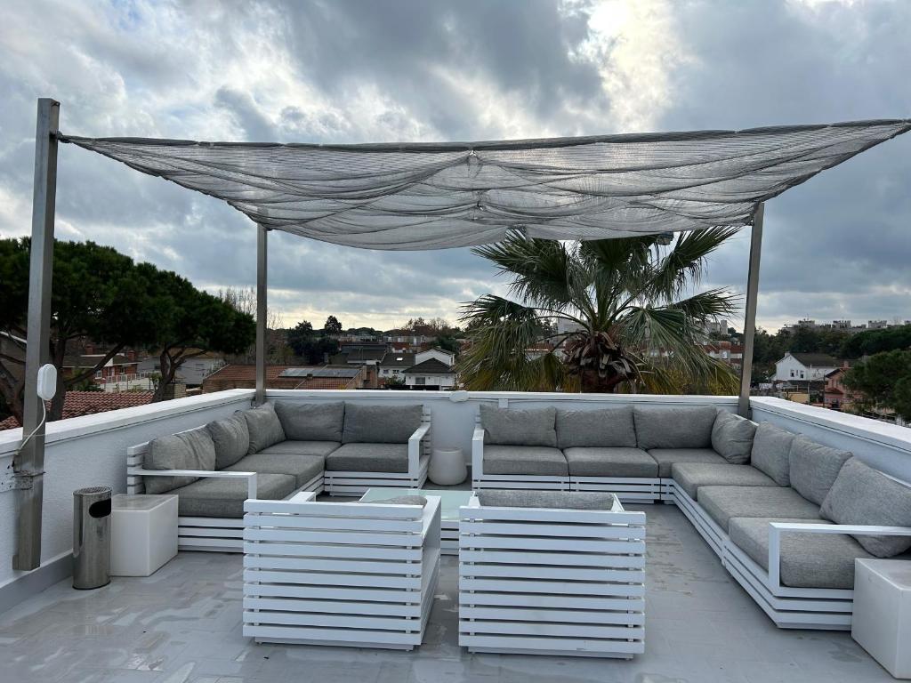 un patio avec un canapé et des chaises sur un toit dans l'établissement Apartamentos ELMA1, à Castelldefels