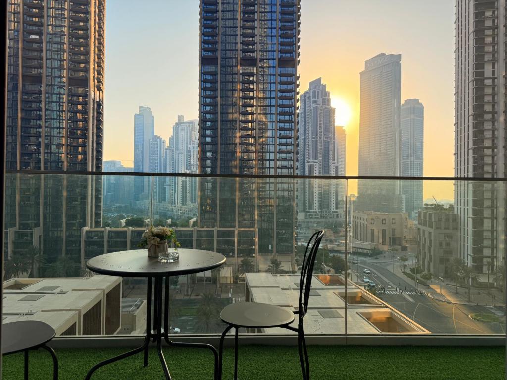 een tafel en stoelen op een balkon met een skyline van de stad bij ULTRA LUXURY 2BR Apartment in Downtown in Dubai