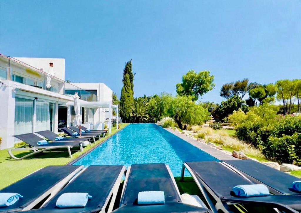 een zwembad met ligstoelen naast een huis bij CASA BRANCA ALGARVE infinity pool & shaded deck in Estói