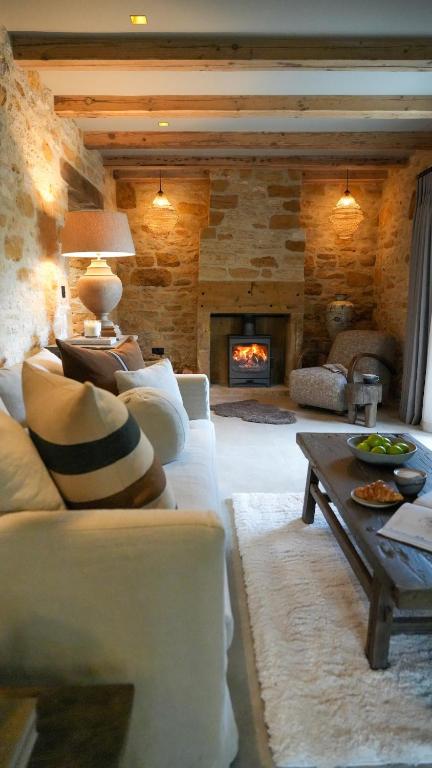 a living room with a white couch and a fireplace at The Library in Moreton in Marsh