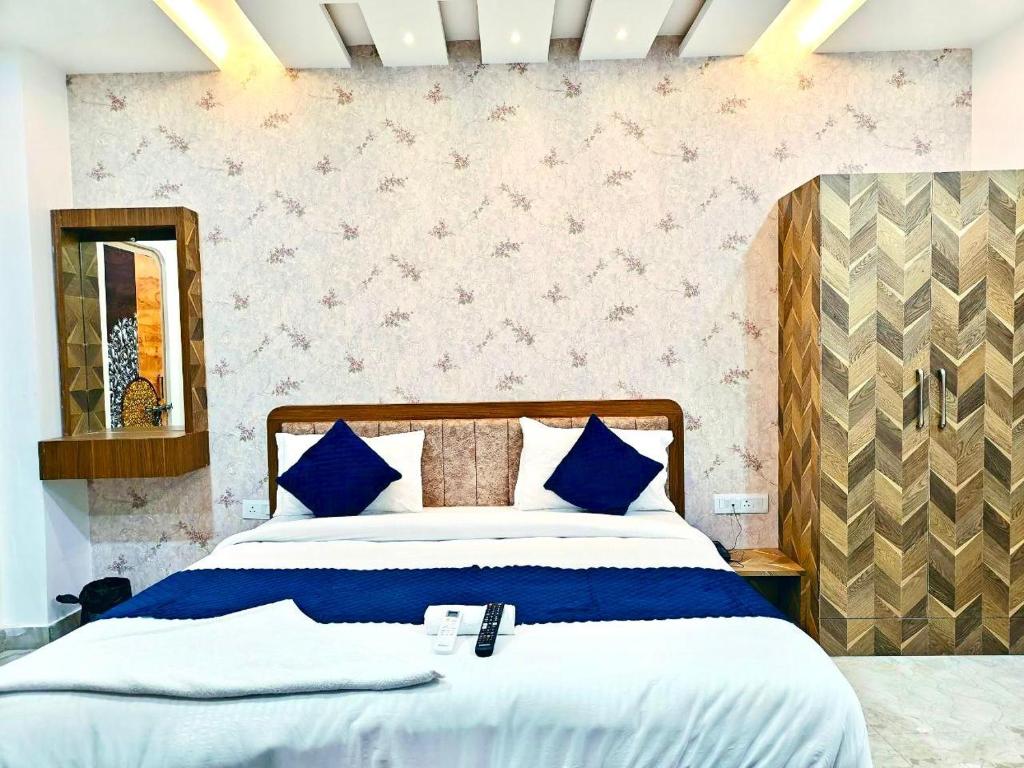 a bedroom with a large bed with blue pillows at Hotel The Pushpraj in Varanasi