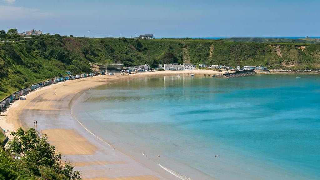 een uitzicht op een strand met mensen in het water bij Hafan Nefyn in Nefyn