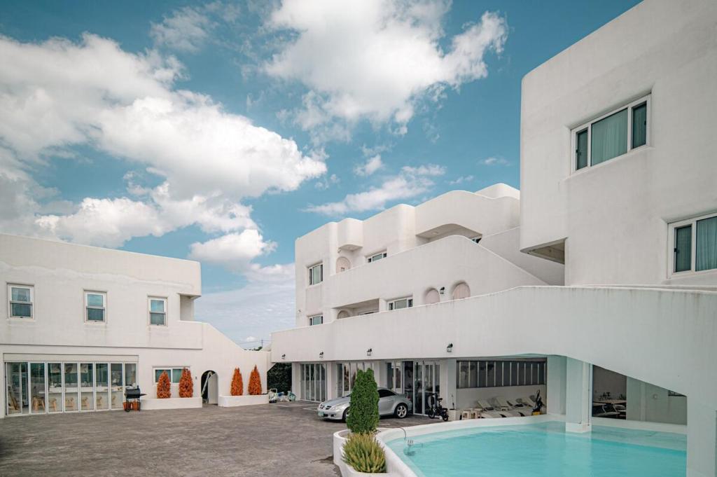 a large white building with a swimming pool in front of it at 레이니데이 in Namŭm-ni