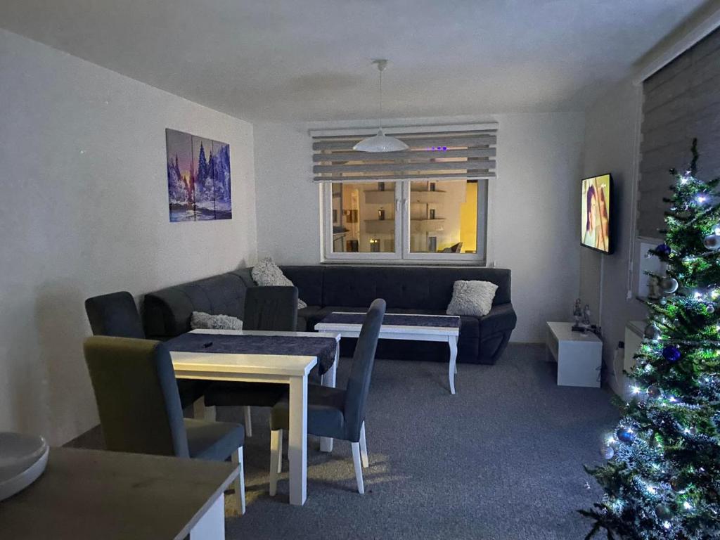a living room with a christmas tree and a couch at Apartman Nova Pale in Pale