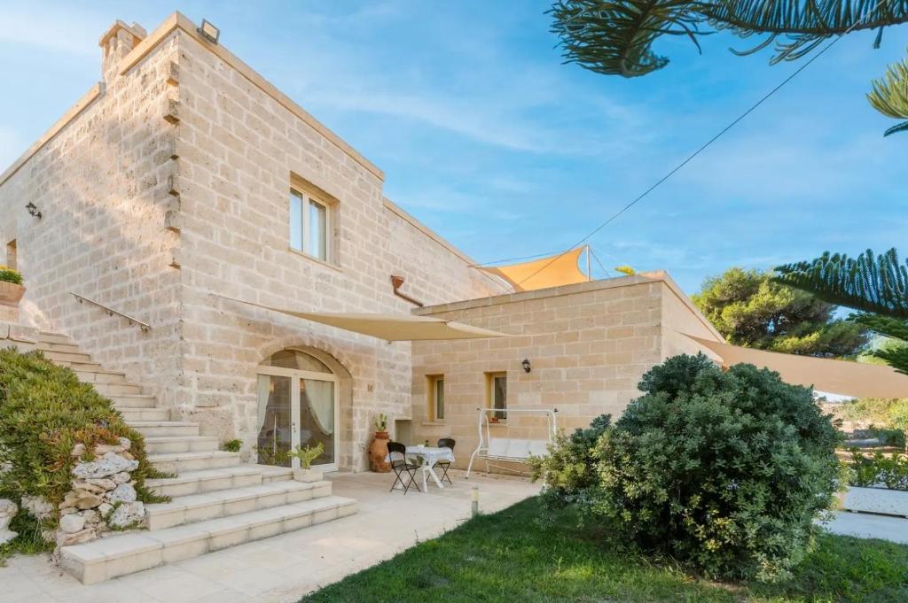 una casa in mattoni con scale e un patio di Antico Casolare P. P. a Otranto