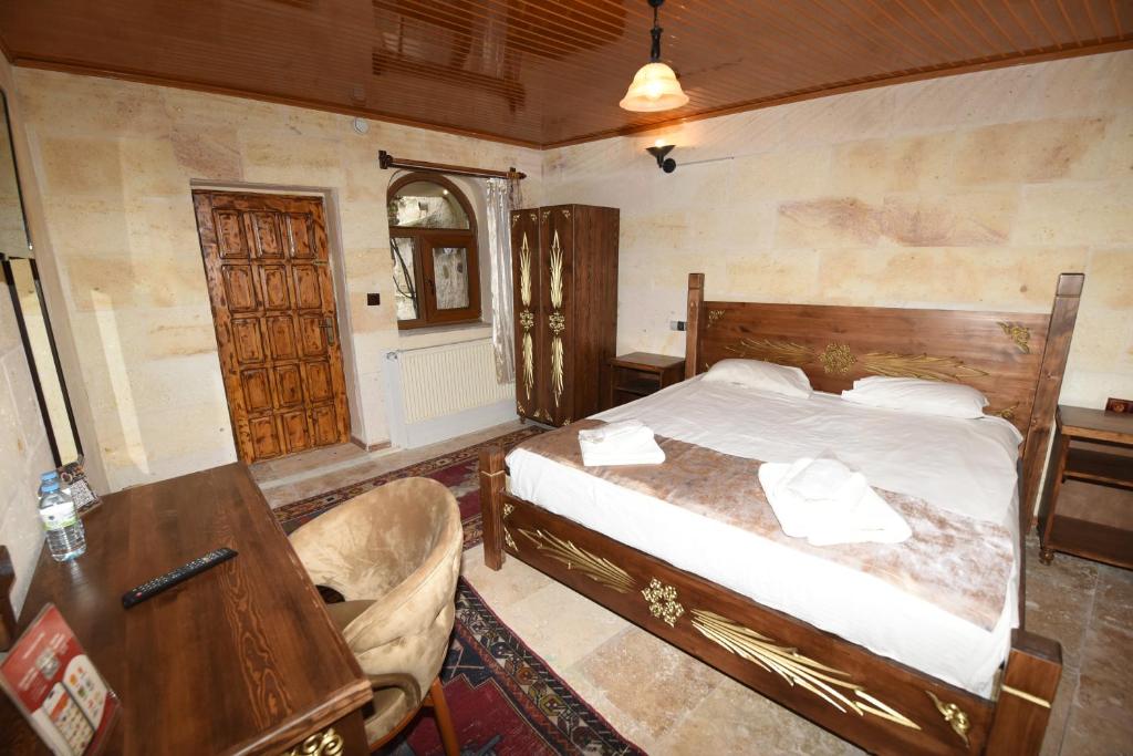 een slaapkamer met een bed, een tafel en een bureau bij Peri Cave Hotel in Goreme