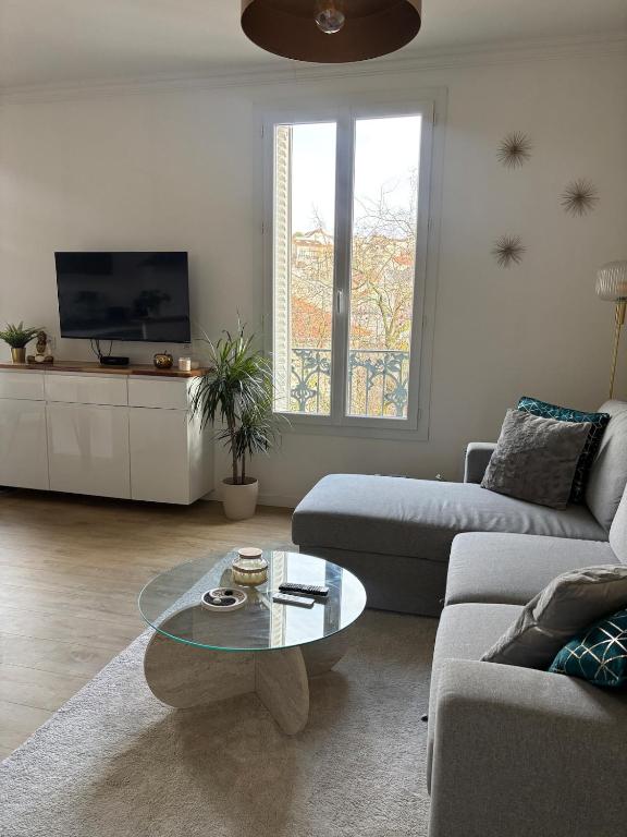 a living room with a couch and a coffee table at Charming modern & bright apartment in Fontenay-sous-Bois
