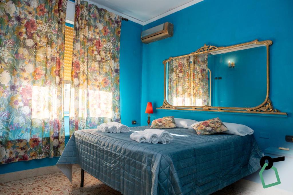 ein blaues Schlafzimmer mit einem Bett mit Handtüchern darauf in der Unterkunft Hotiday Palermo Agostino in Palermo