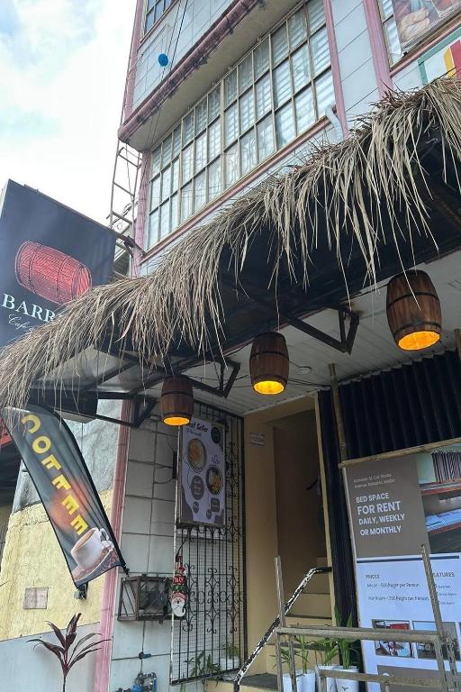 a restaurant with a straw umbrella and lights on it at Barelle Hostel, Coffee and Wine Bar in Kalibo