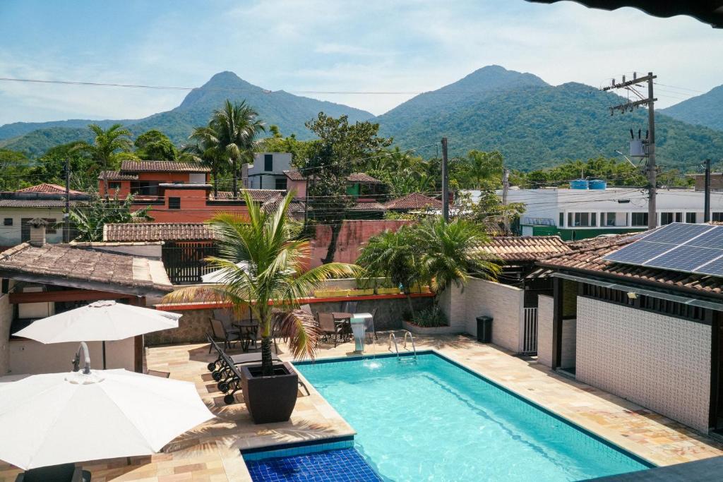 a pool on the roof of a building with mountains in the background at VELINN Pousada Face Norte in Ilhabela