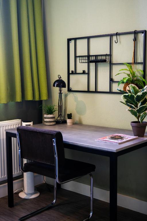 a desk with a chair in a room with plants at Short Stay Wageningen in Wageningen