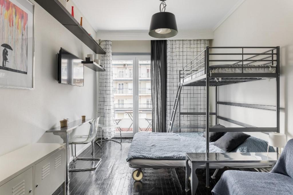 塞萨洛尼基Restored, immaculate condo @ historic center #1的有两张双层床和一张书桌的房间