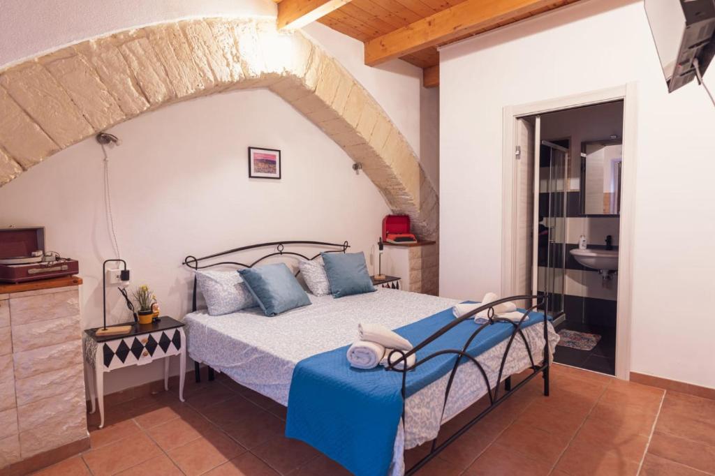 een slaapkamer met een bed met blauwe kussens bij Sassari Station Inn in Sassari
