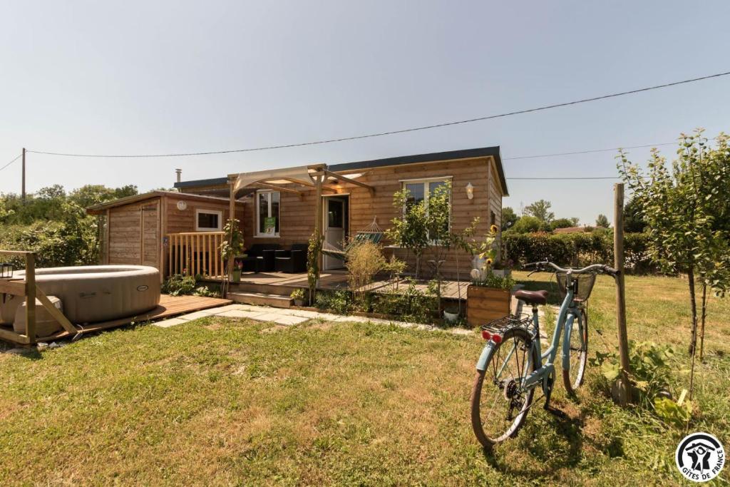 a bike parked in front of a tiny house at Le panier bio de noé in Noé