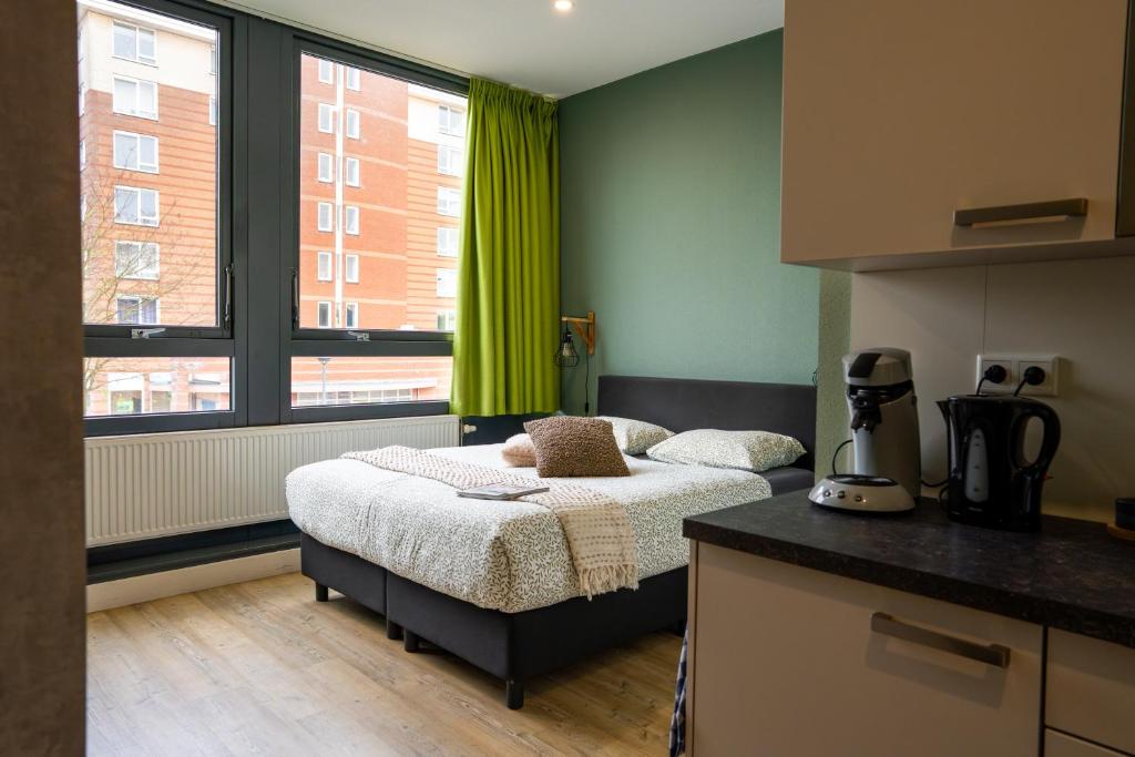 ein Schlafzimmer mit einem Bett und einem großen Fenster in der Unterkunft Short Stay Wageningen in Wageningen