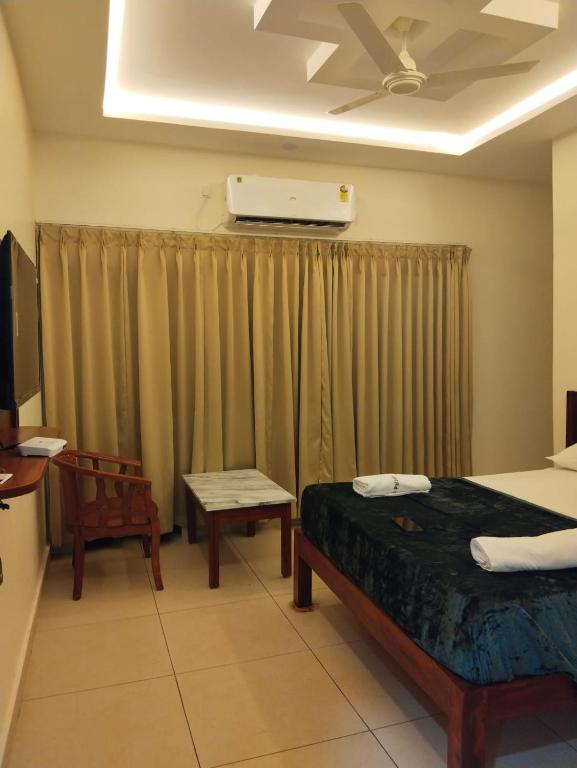 a room with a bed and a tv and curtains at Prestige Palace in Mugad