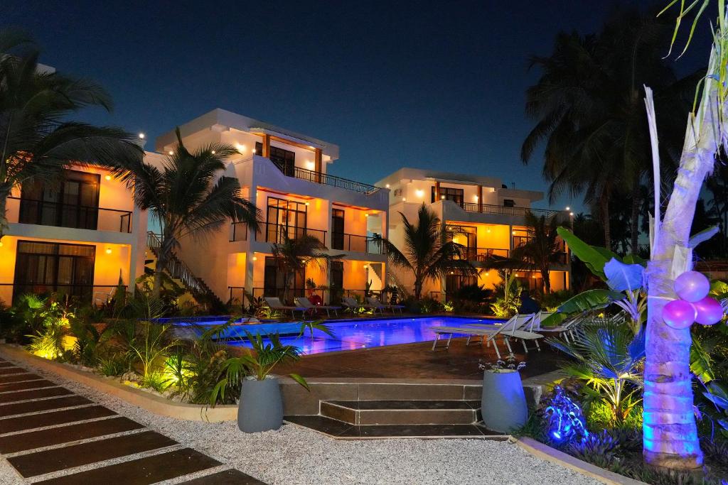a house with a swimming pool at night at Changarawe Hotel & Retreat in Pongwe