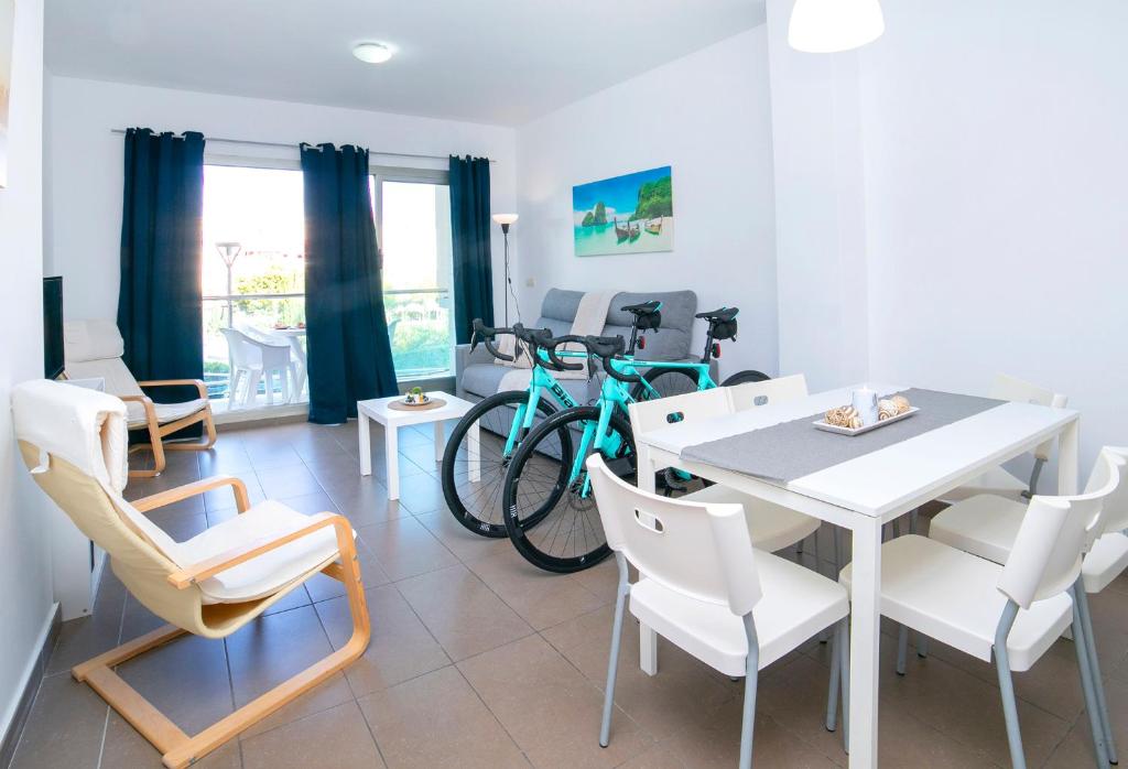 een eetkamer met een tafel en stoelen en een fiets bij Homeincalpe Borumbot in Calpe