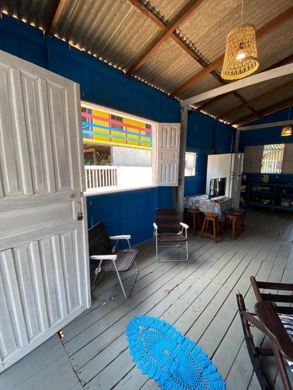 a room with a white door and chairs on a wooden floor at Casa de Praia LUÁ in Bragança
