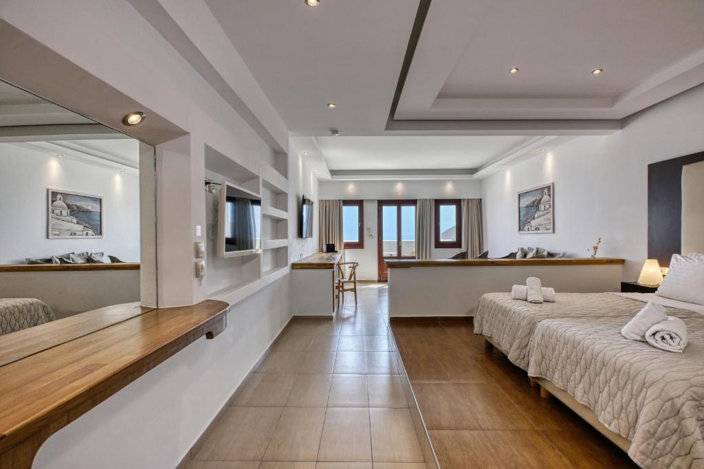 a hotel room with two beds and a bathroom at Splendour Hotel and Suites in Firostefani