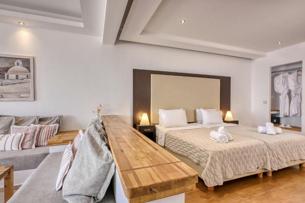 a bedroom with two beds and a couch at Splendour Hotel and Suites in Firostefani