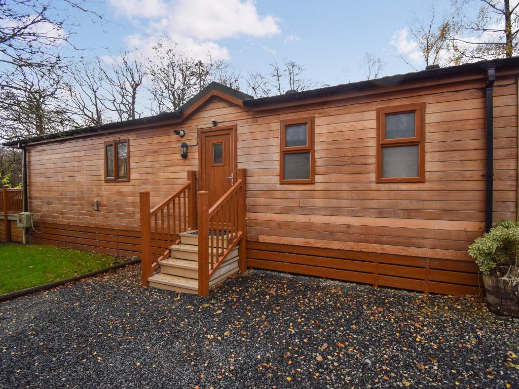 une cabane en rondins avec un escalier et une maison dans l'établissement Bluebird Lodge 2 - Uk50932, à High Nibthwaite
