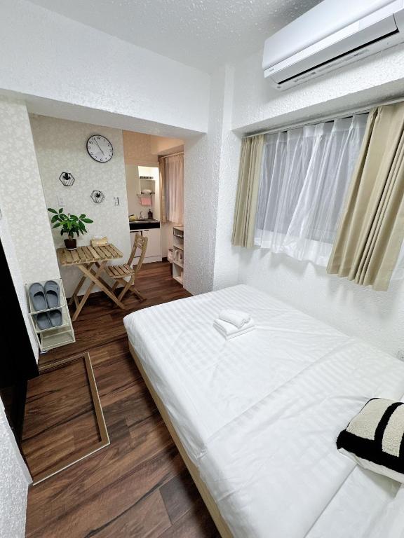 a bedroom with a large white bed in a room at Katsu hotel 3号机场直通 in Osaka
