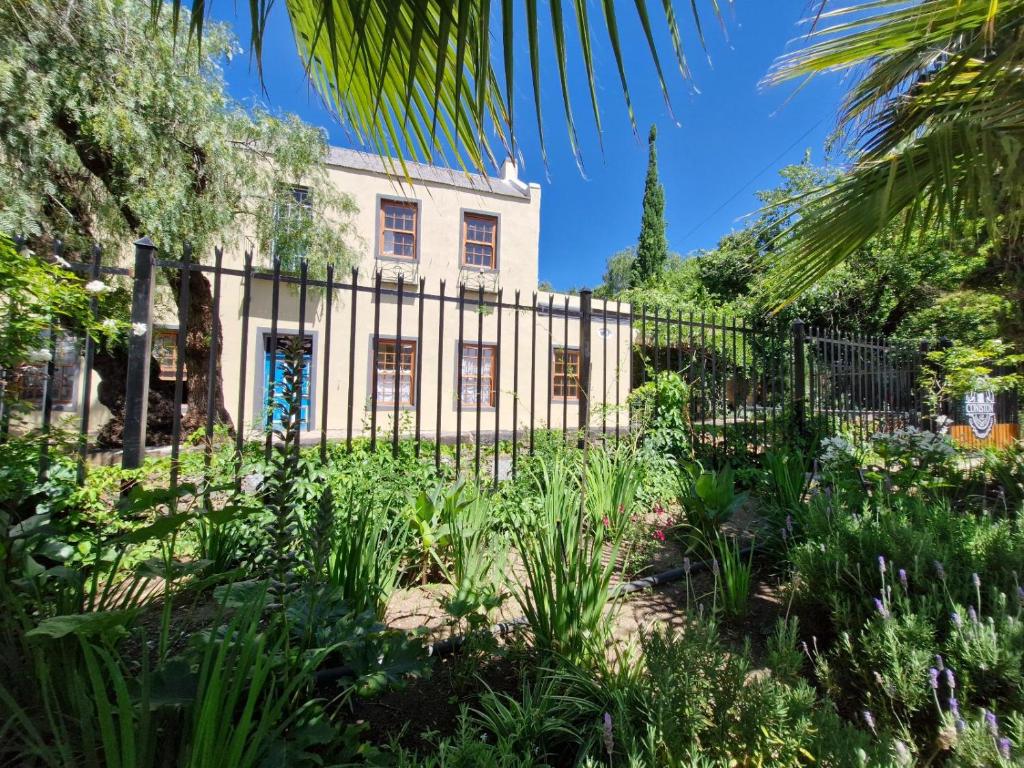 a garden in front of a building with a fence at Coniston Villa in Colesberg